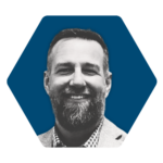 a professional headshot of DC Norris North America Sales Engineer, Brian Irwin. Brian is smiling. The photo of Brian is stylized in black and white and the background is a navy blue hexagon.