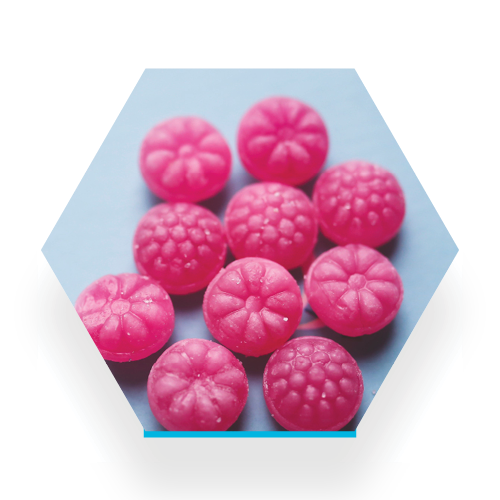 pink hard candies on a light blue background, unwrapped candies look like pastilles