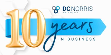 a white banner with a golden number 10 on it. The banner reads "DC Norris North America 10 Years in Business"