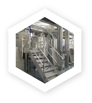 image of stairs leading up to a large bank of stainless steel industrial cooking kettles
