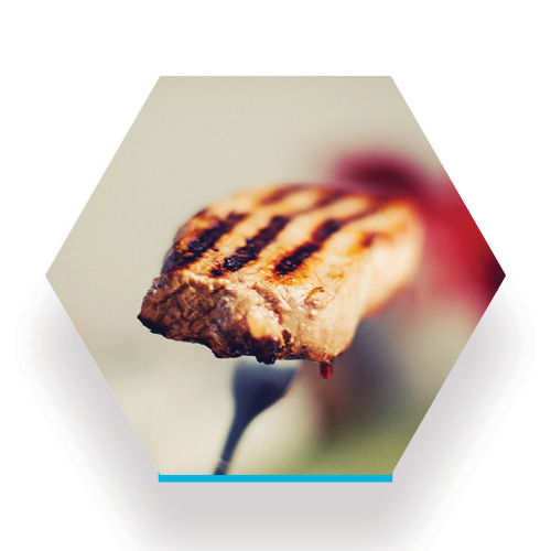 a fork holds a bite of chicken fresh from the grill with perfect sear markings