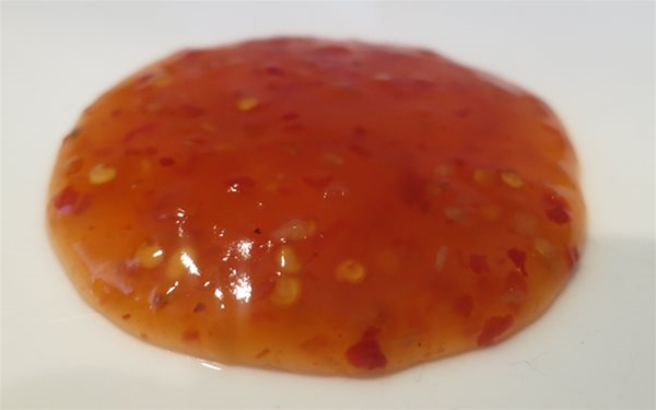 close up shot of sweet chili dipping sauce dabbed on a plate after a successful trial production run